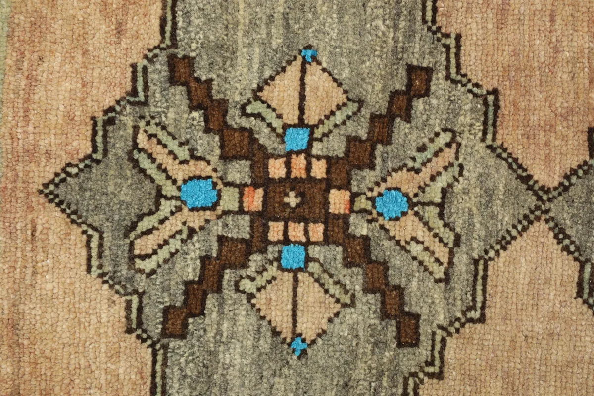 Detailed view of a central geometric motif with brown, orange, and blue accents on a gray-olive background.