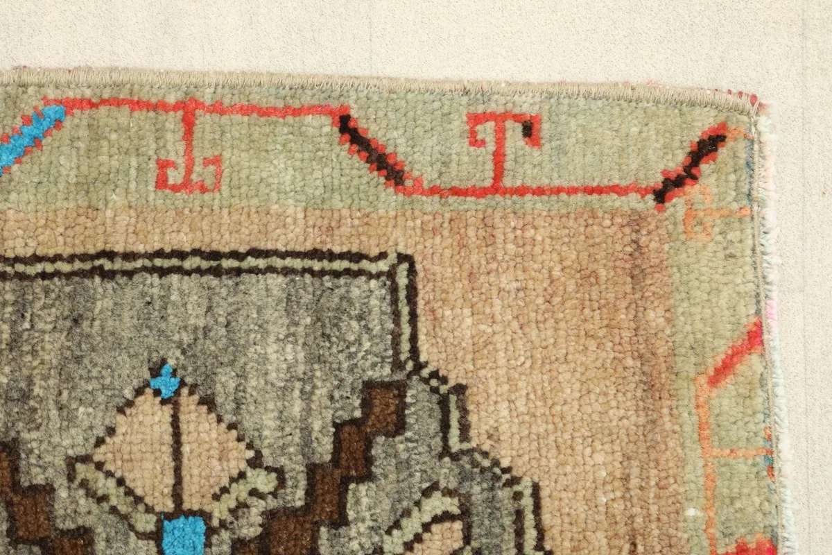 Close-up of the rug's border and a portion of the central pattern, highlighting the color transitions and weave.