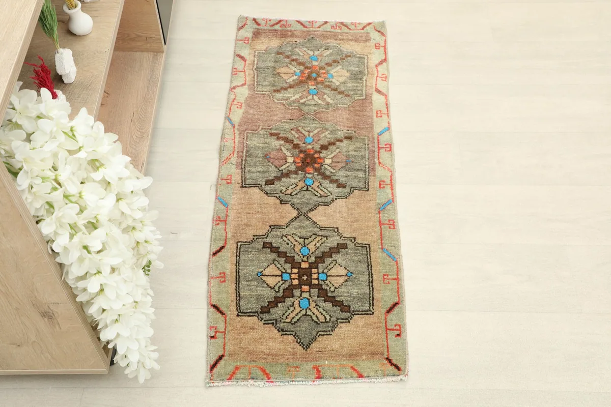 Overhead view of the beige and olive vintage runner, showing its full length and tribal geometric patterns.