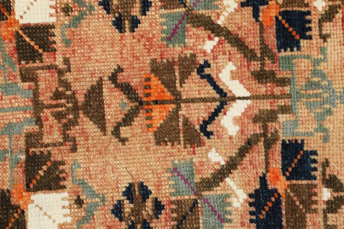Detailed view of the hand-knotted wool pile and intricate tribal patterns.