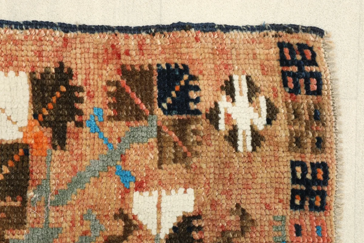 Close-up of the red section and beige field, highlighting the small, varied geometric shapes.