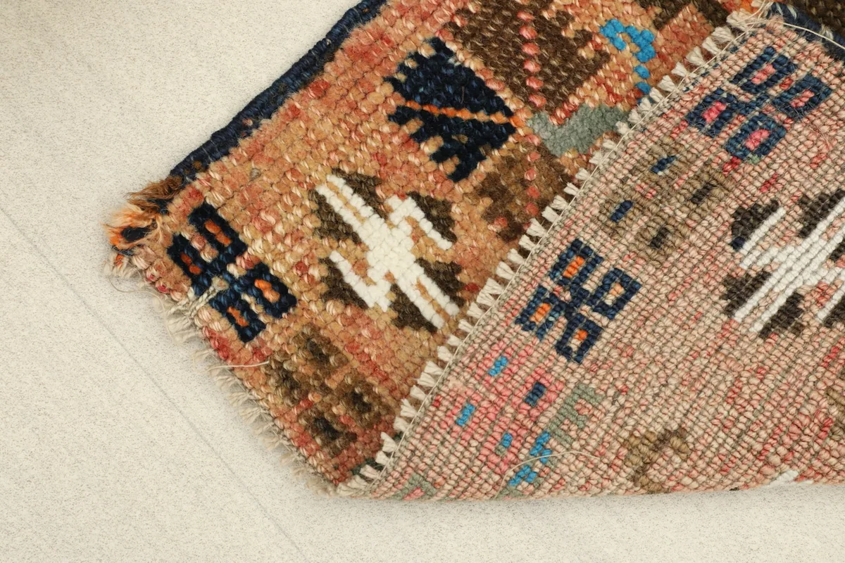 View showing the low wool pile texture and the rug's flexibility when folded.