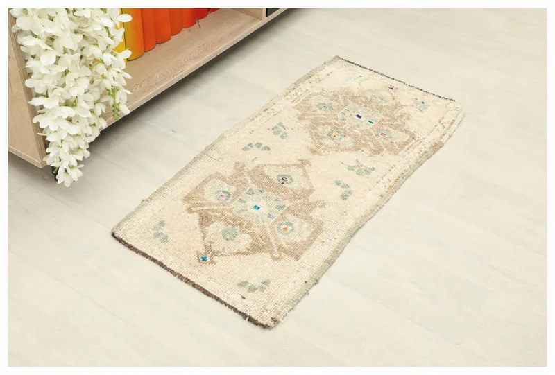 Full top view of the 1'6" x 3'1" ivory vintage Anatolian doormat with brown geometric patterns