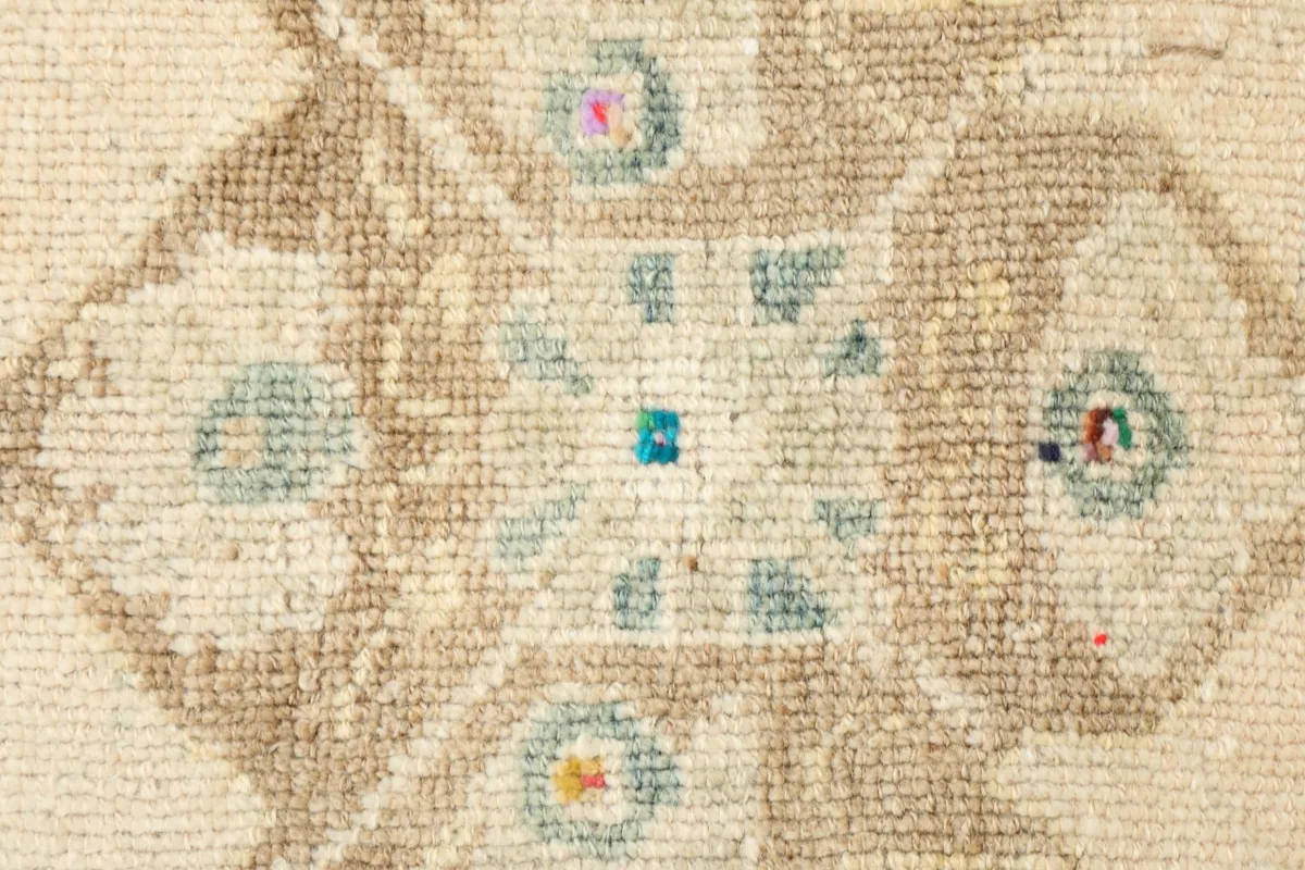 Close-up detail of the central geometric motif with small blue, pink, and yellow accents