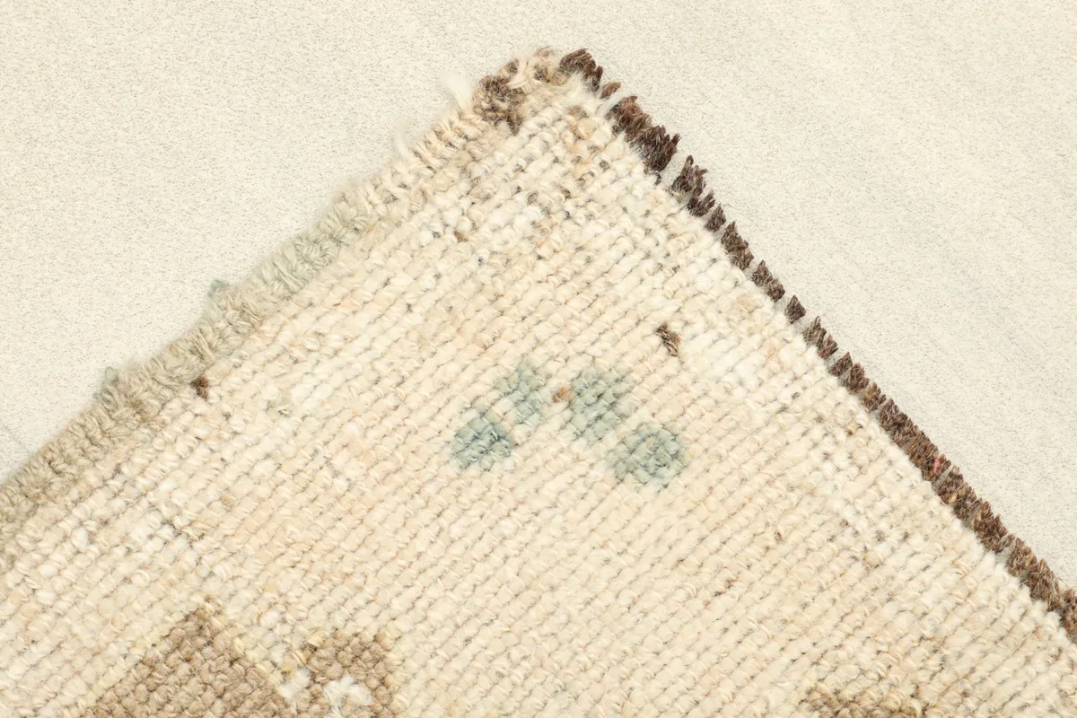 Corner view showing the reverse side of the hand-knotted rug and its cotton foundation