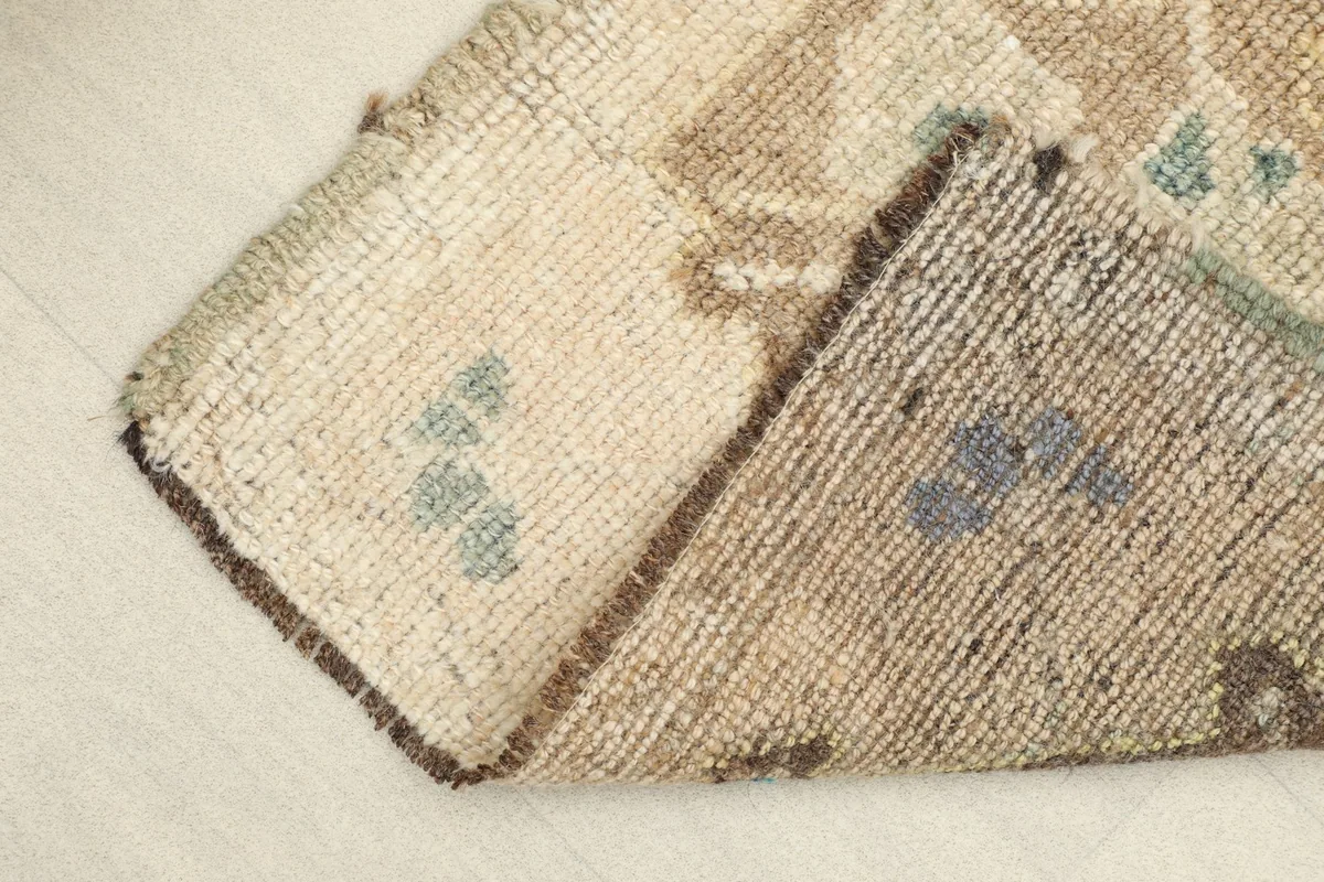 Rug corner folded to show the thickness and construction of the wool pile and cotton foundation