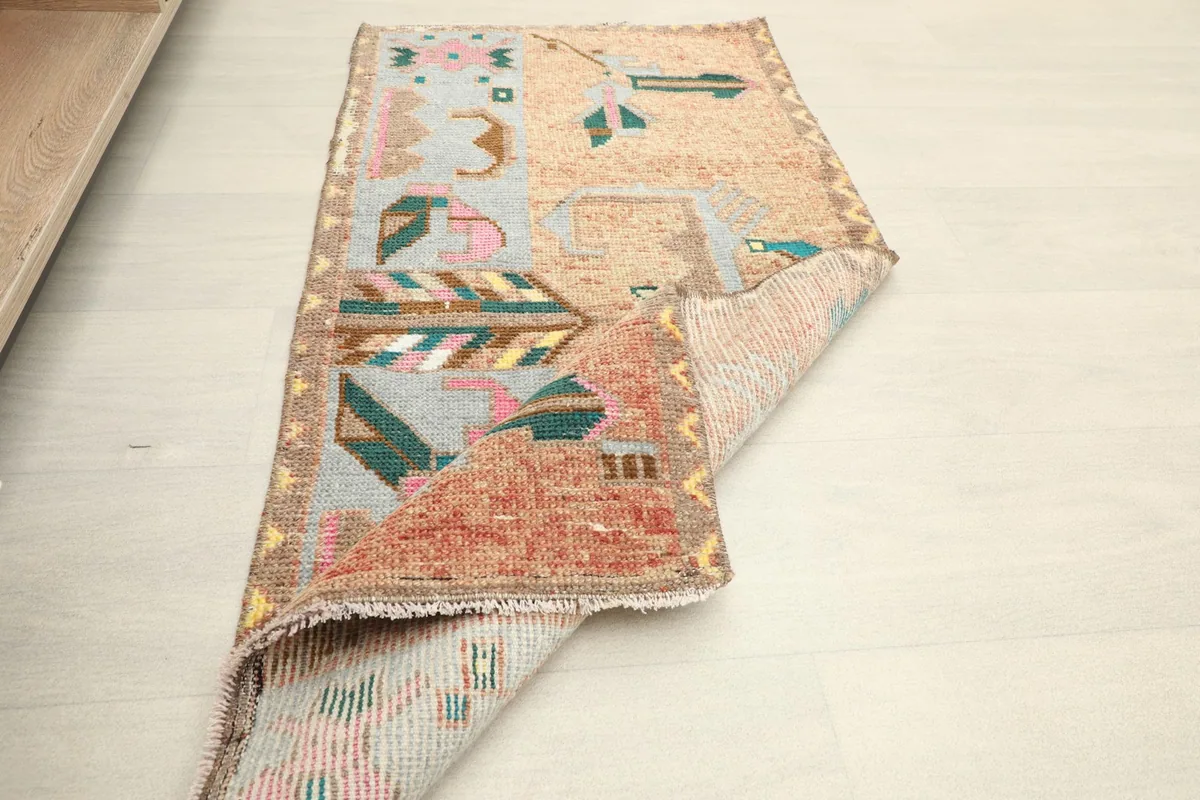Angled view of the rug, showing its texture and how it lays on the floor, partially rolled.