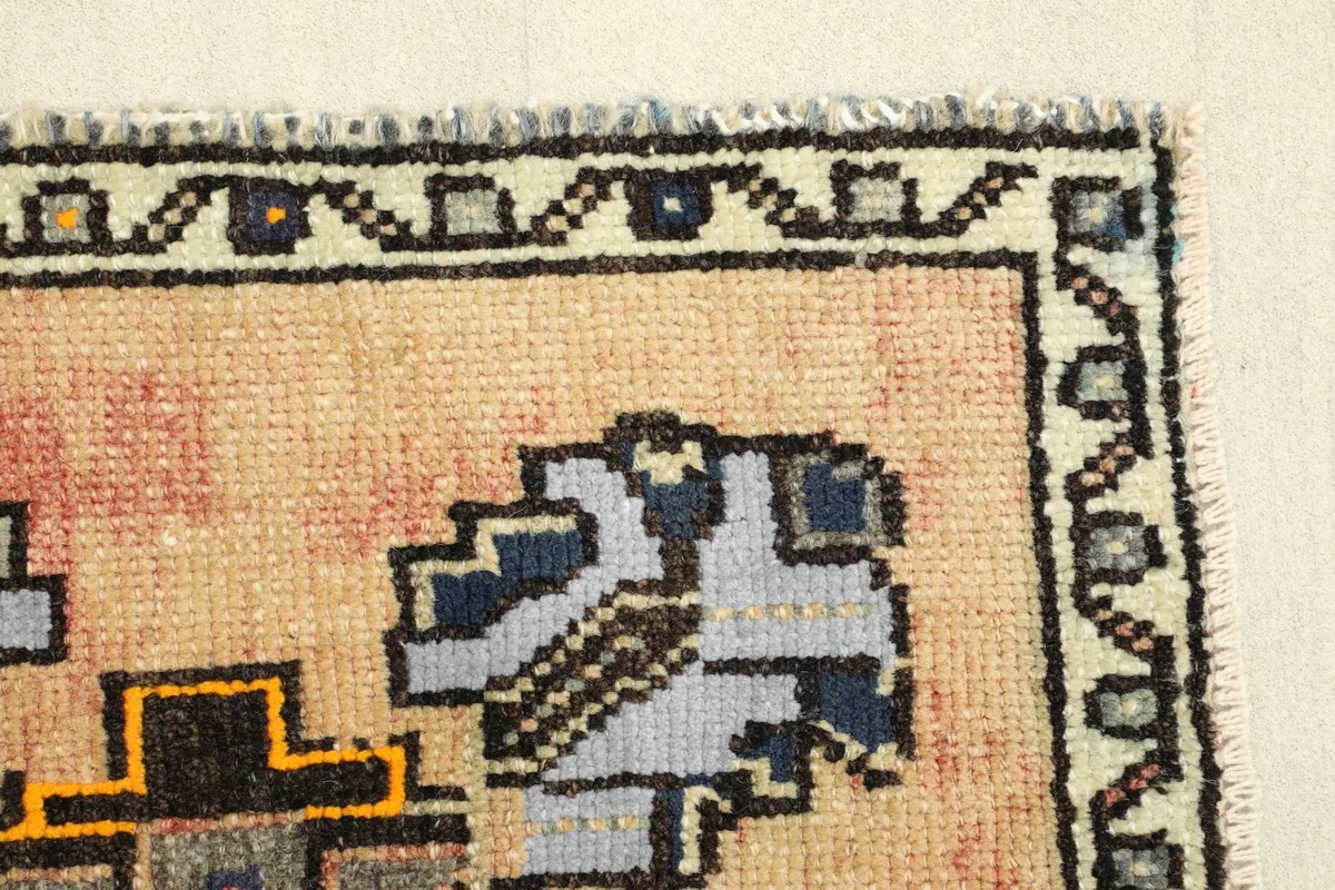 Close-up of the beige field and a blue geometric element, showing the wool pile.
