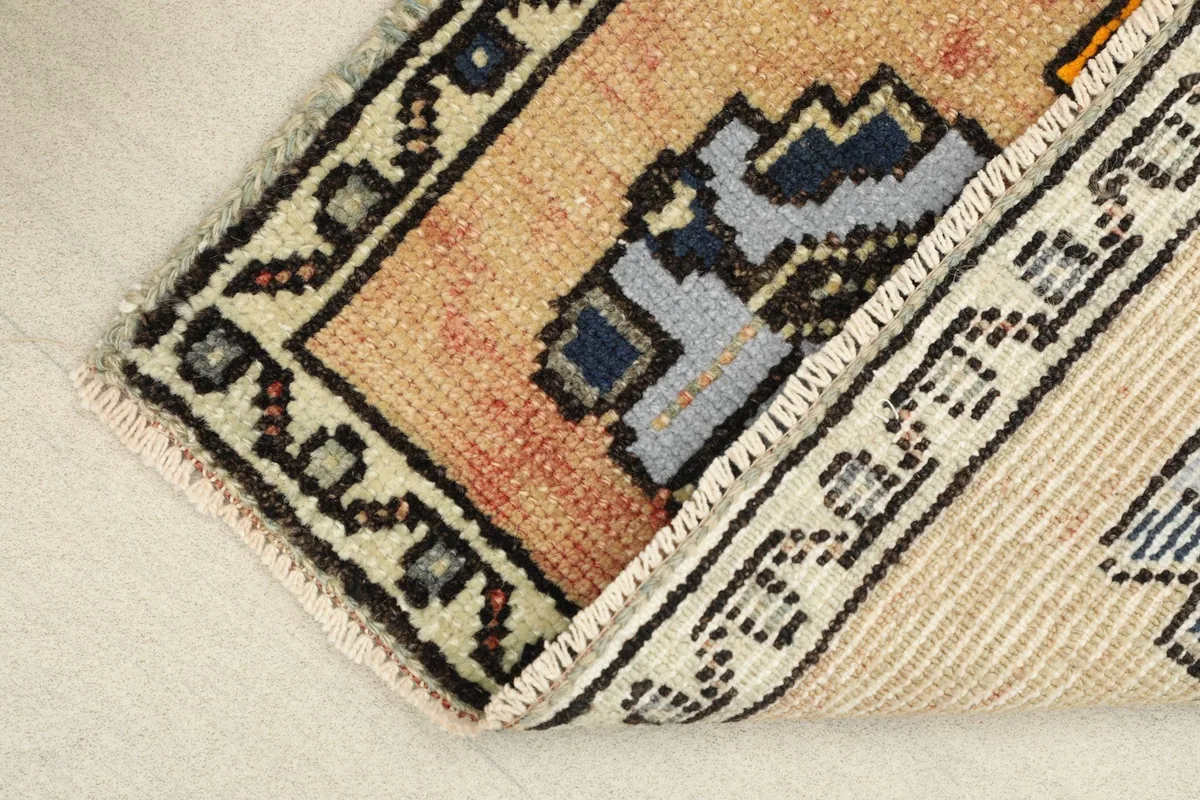View of the rug's corner folded to reveal the cotton foundation and hand-knotted construction.