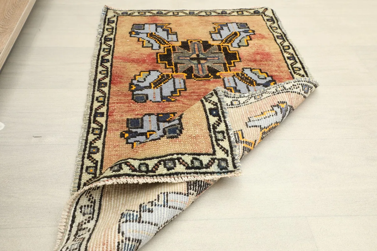 The rug partially folded, showing the reverse side and the texture of the wool pile.
