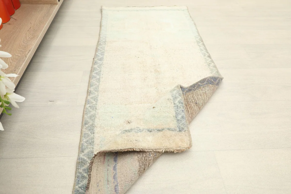 Angled view of the rug partially rolled, demonstrating its size and how it lays on the floor.