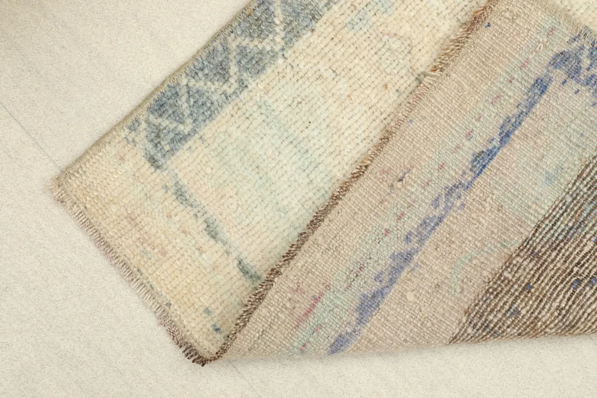 View of the rug folded to show the flexibility and thickness of the vintage wool pile.