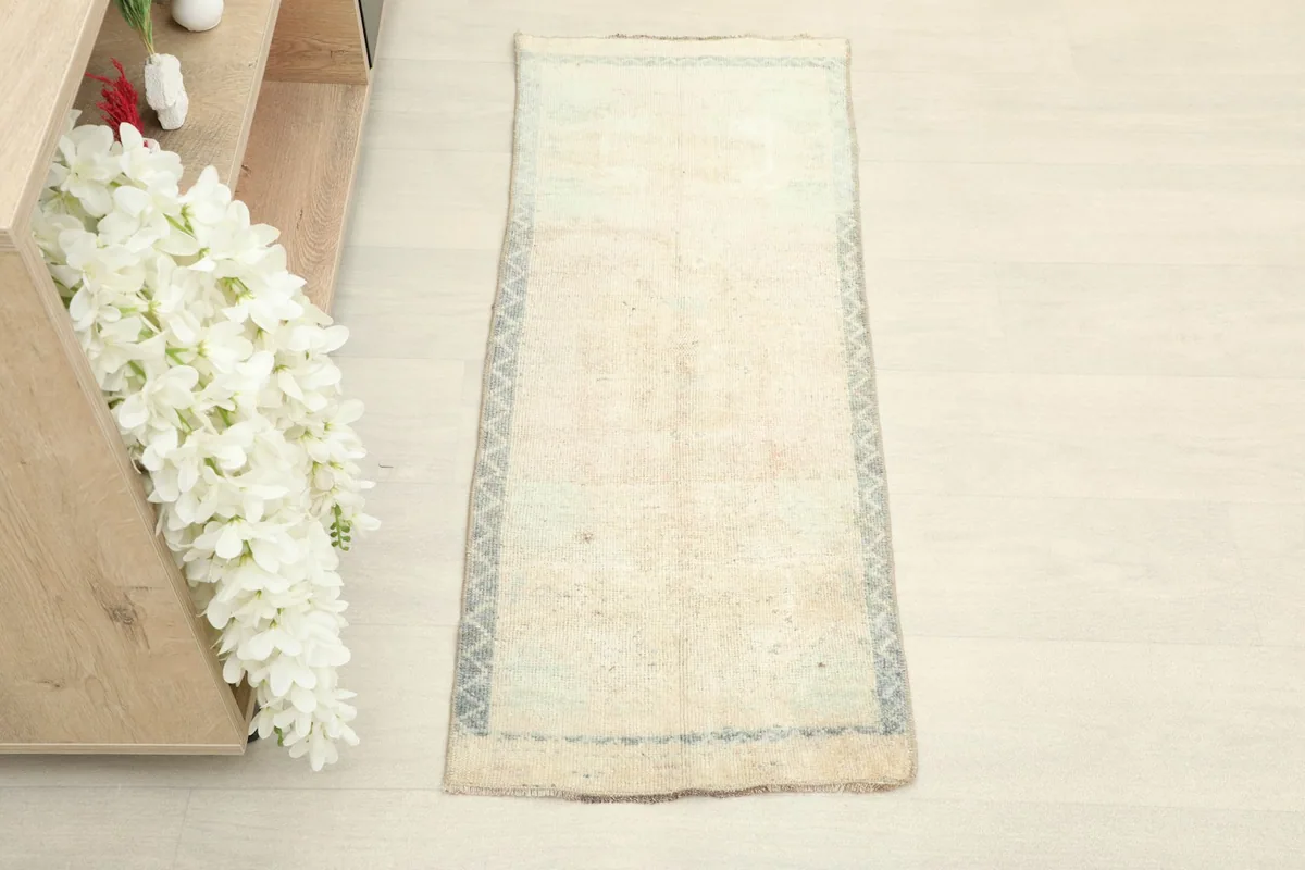 Overhead shot of the small hand-knotted wool doormat, showing its rectangular shape and colors.