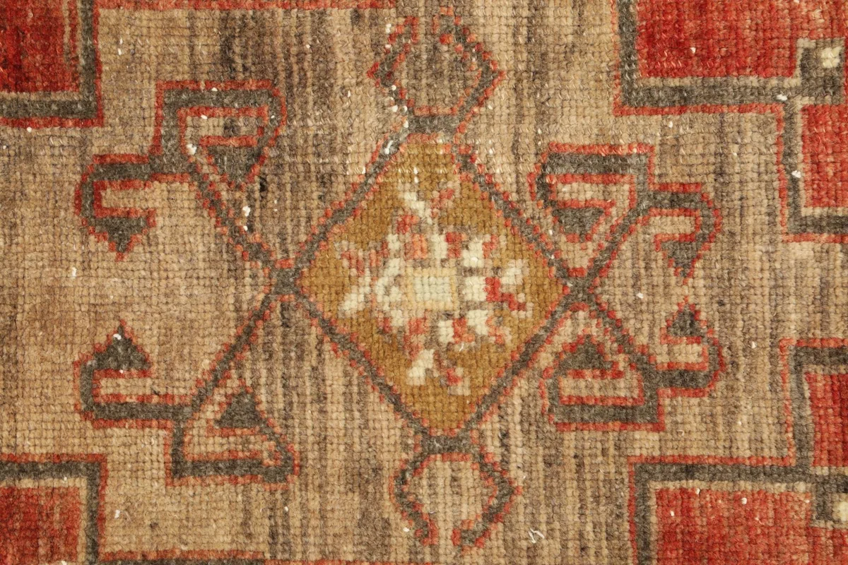 Tight detail shot of the rug's center, highlighting the yellow and ivory accents within the main motif