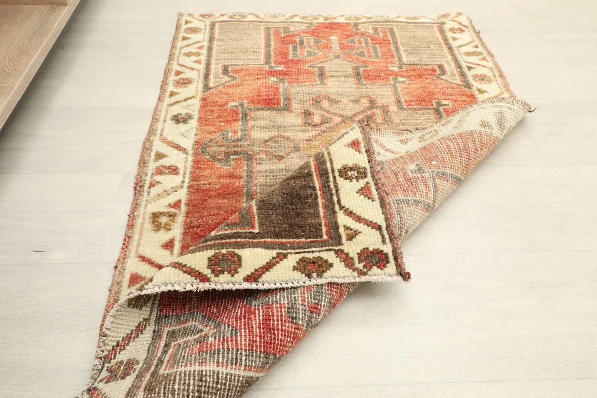 Partial fold of the rug, displaying the flexibility and the construction of the vintage wool piece