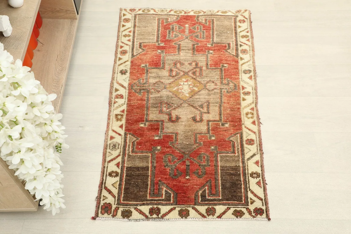 Overhead view showcasing the intricate geometric design and color variation of the red and beige vintage rug