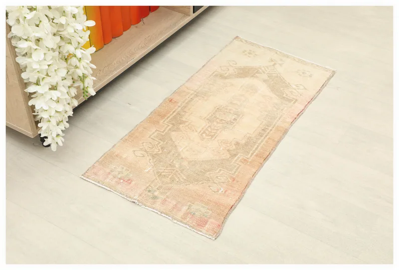 Full top view of the beige and rust vintage Anatolian doormat rug on a white background.