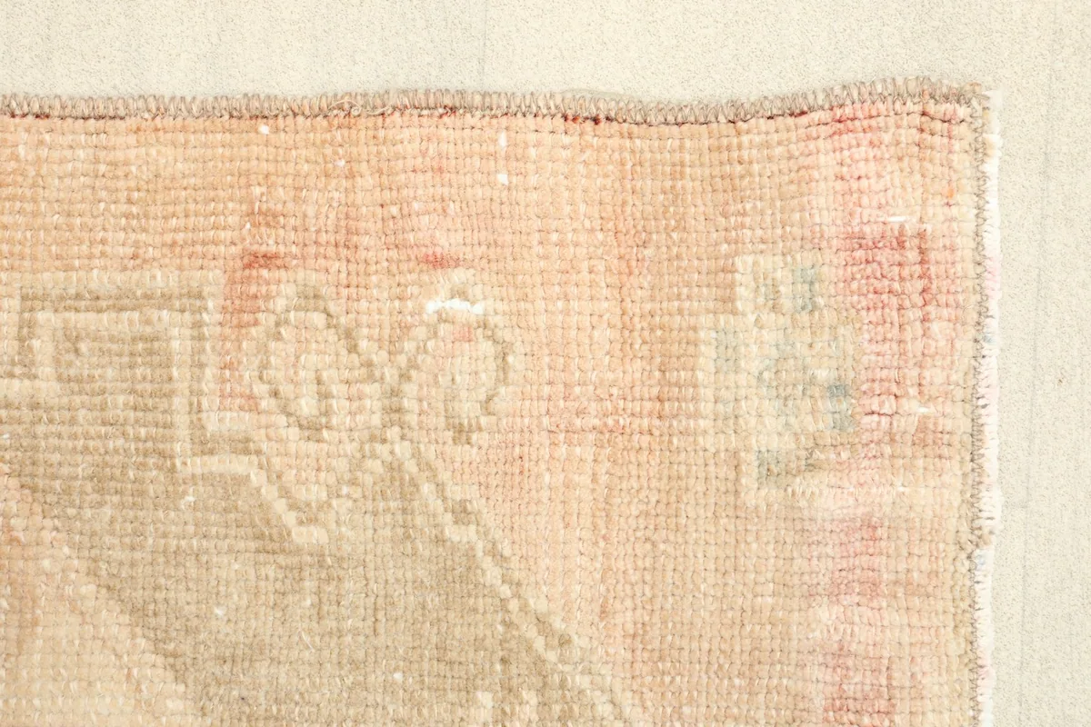 Close-up of the rug's border and a portion of the main field, showing color variations.