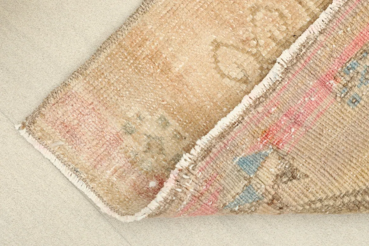 View of the rug's low pile and the texture of the hand-knotted wool on cotton foundation.