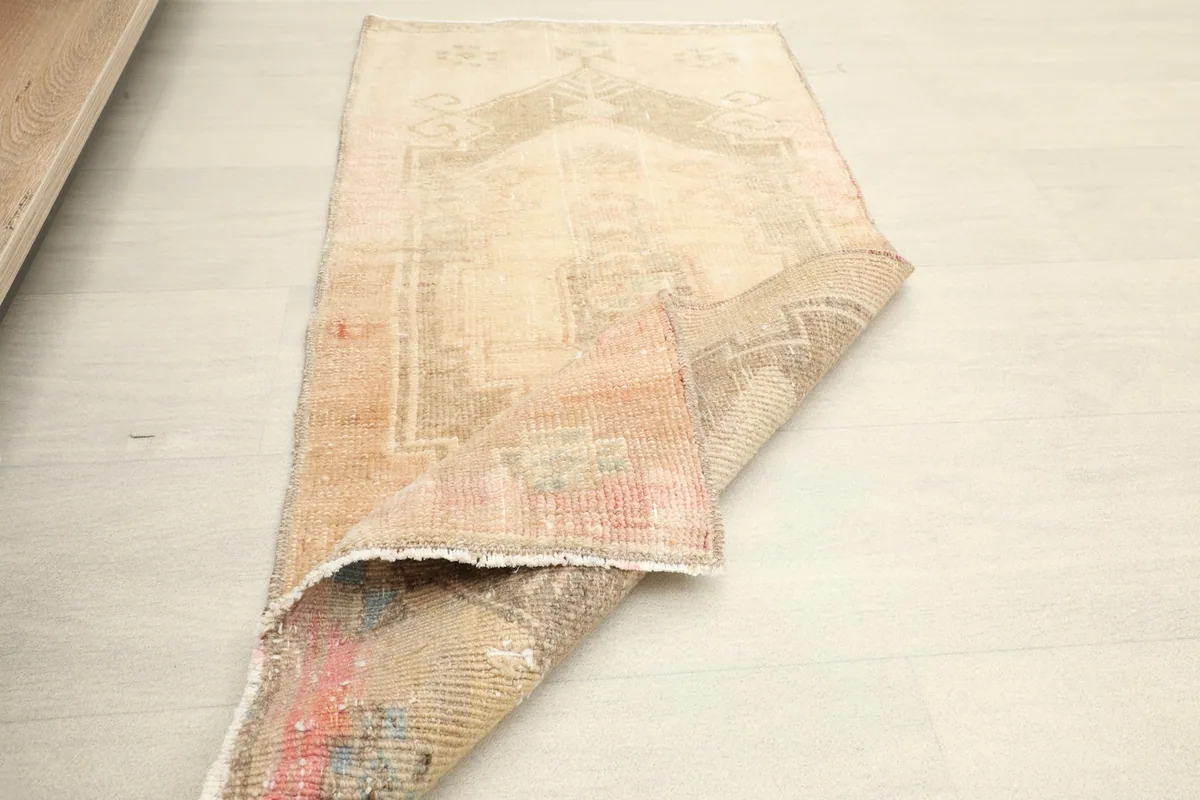 The vintage rug folded to display the underside and the overall size and flexibility.