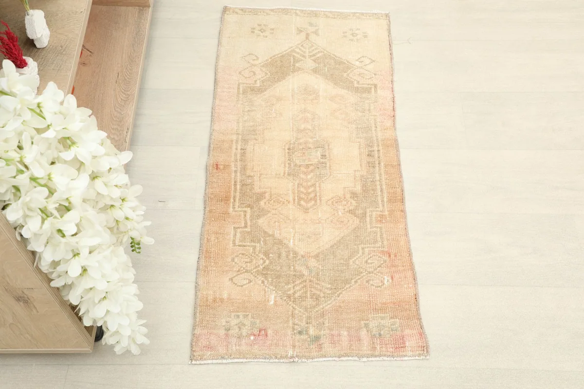 Overhead view showcasing the full length of the hand-knotted beige and rust tribal rug.