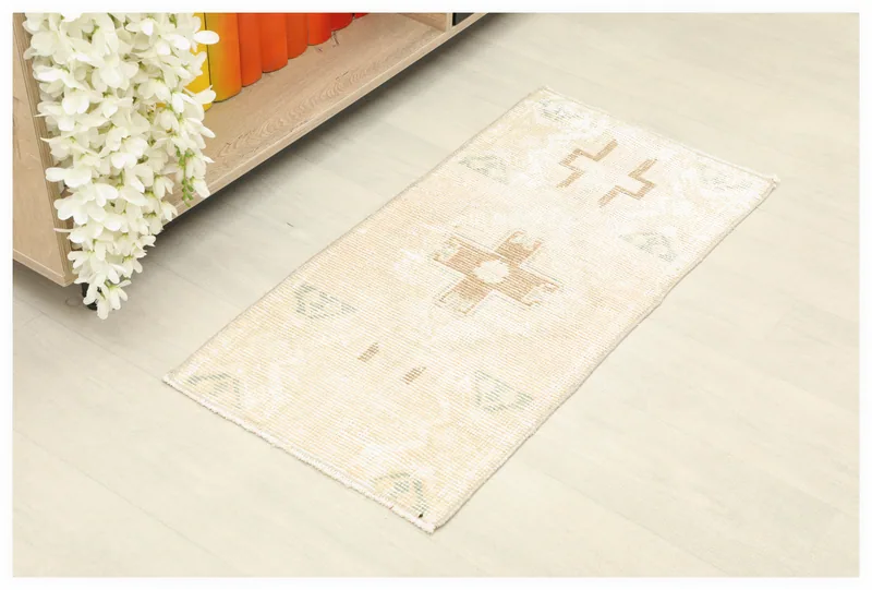 Full overhead view of the 1x3 ivory and beige geometric vintage Anatolian rug on a light floor.