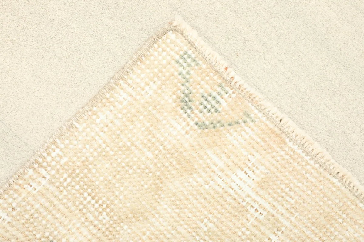 Close-up of a corner of the rug, showing the subtle green accents within the geometric design.