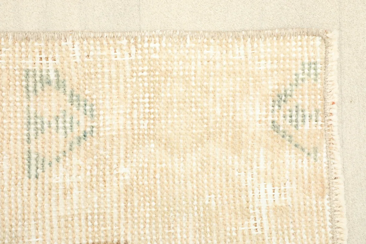 Another detailed view of the rug's edge, focusing on the muted colors and hand-knotted texture.