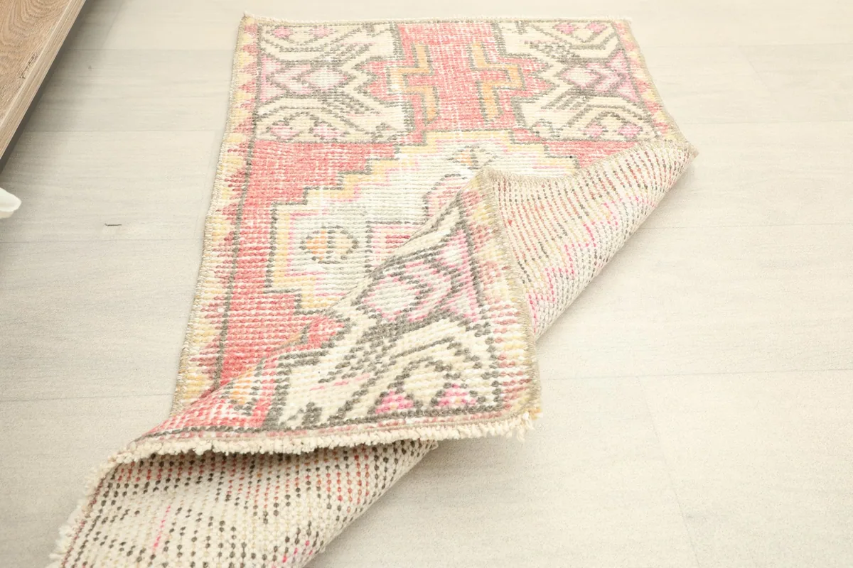 Partial fold of the rug showing both the front wool pile and the tightly woven cotton foundation on the reverse.