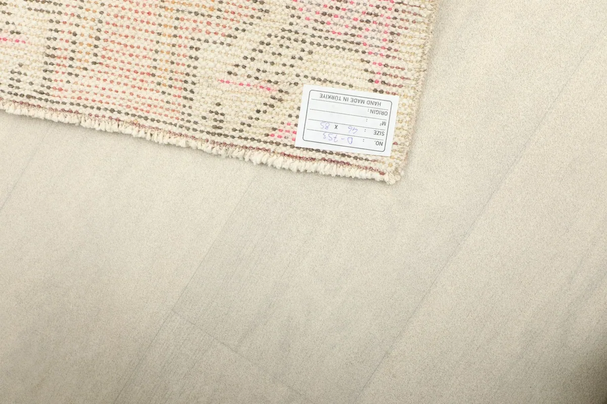 Close-up of the rug's corner with the product label, showing information about its origin and material.