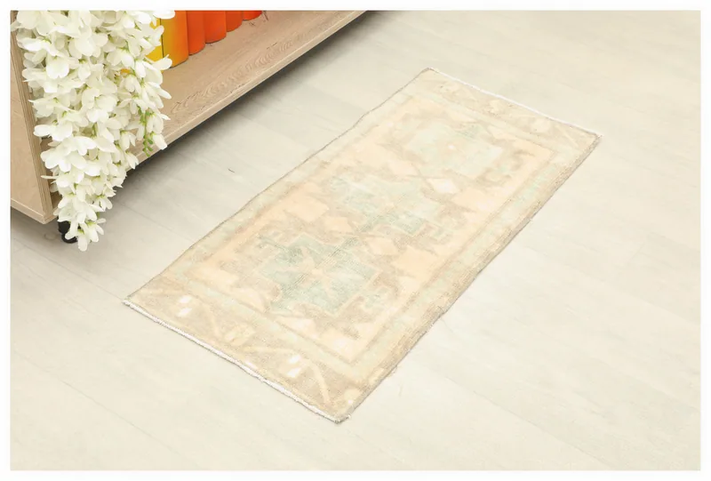 Full top view of the beige and green geometric Anatolian rug on a light floor