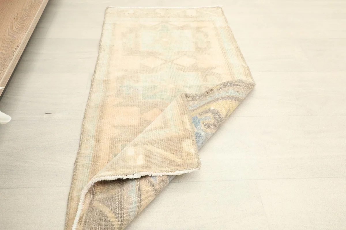 Rug partially folded, showing the flexibility and construction from the side