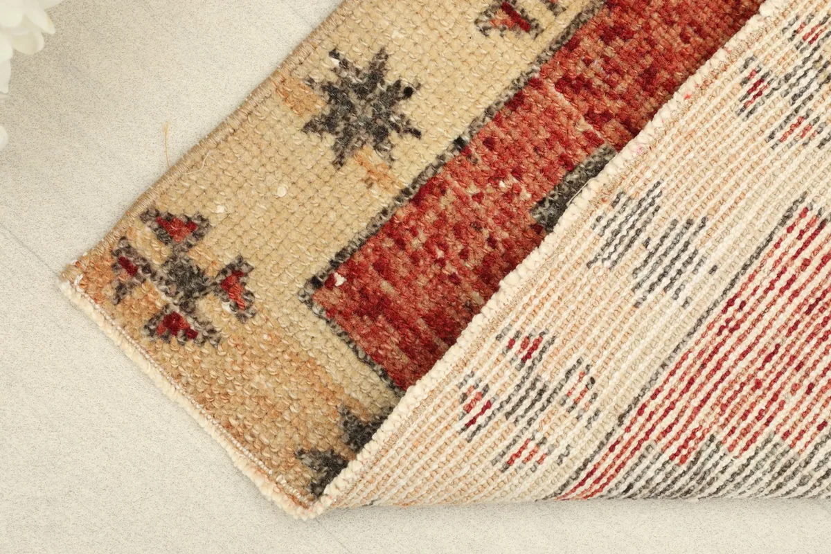 Folded view revealing the wool pile texture and cotton foundation of the vintage rug