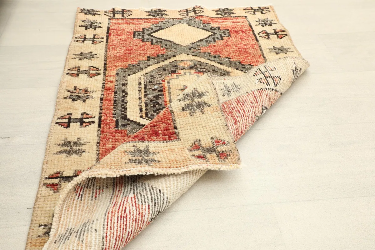 Angled view of the rug with one corner folded back, showing the back weaving and colors