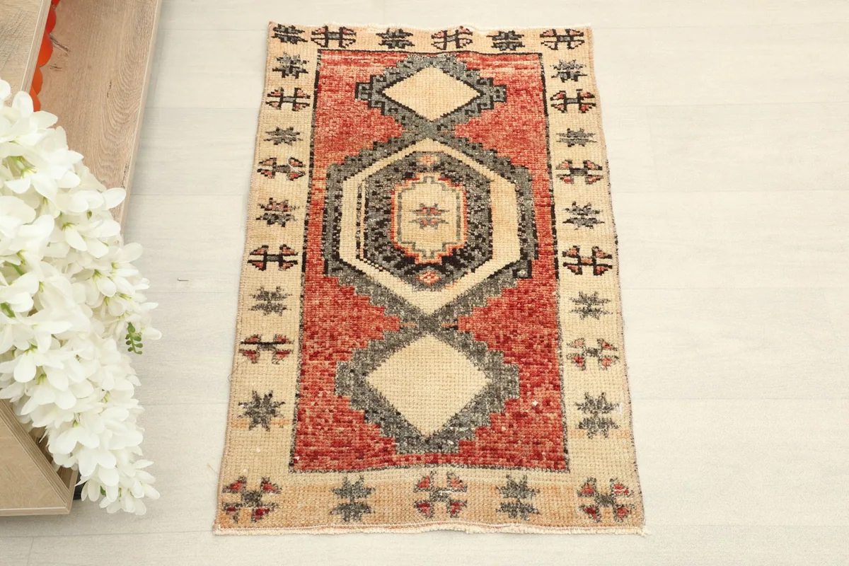 Overhead view of the red and beige vintage rug, showcasing its geometric and tribal patterns