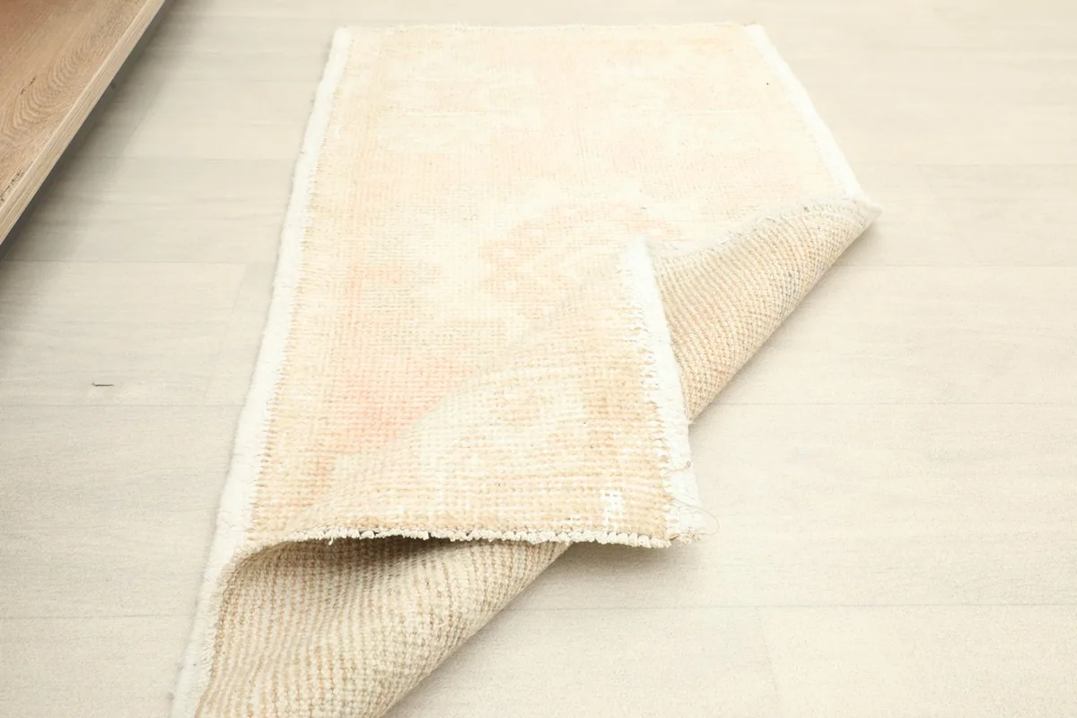 The rug partially folded on a light floor, showing its flexibility and thickness.
