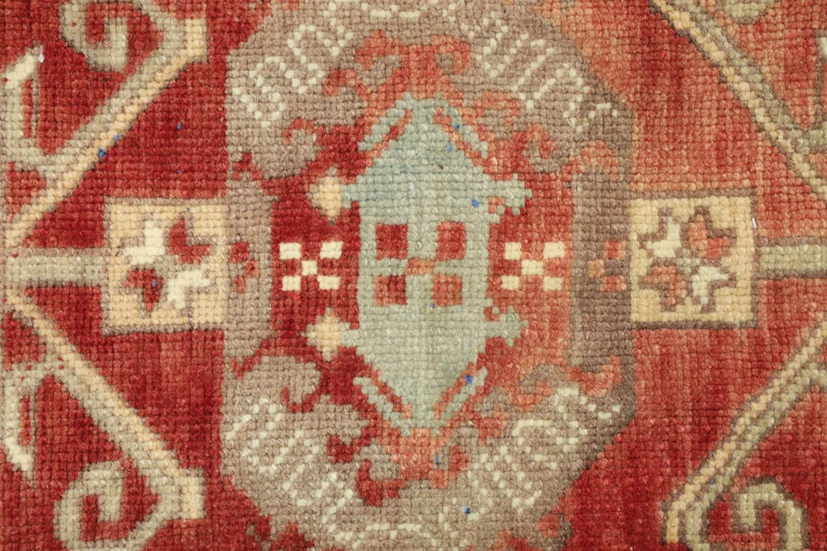 Detailed view of the central geometric motif in red, beige, and gray