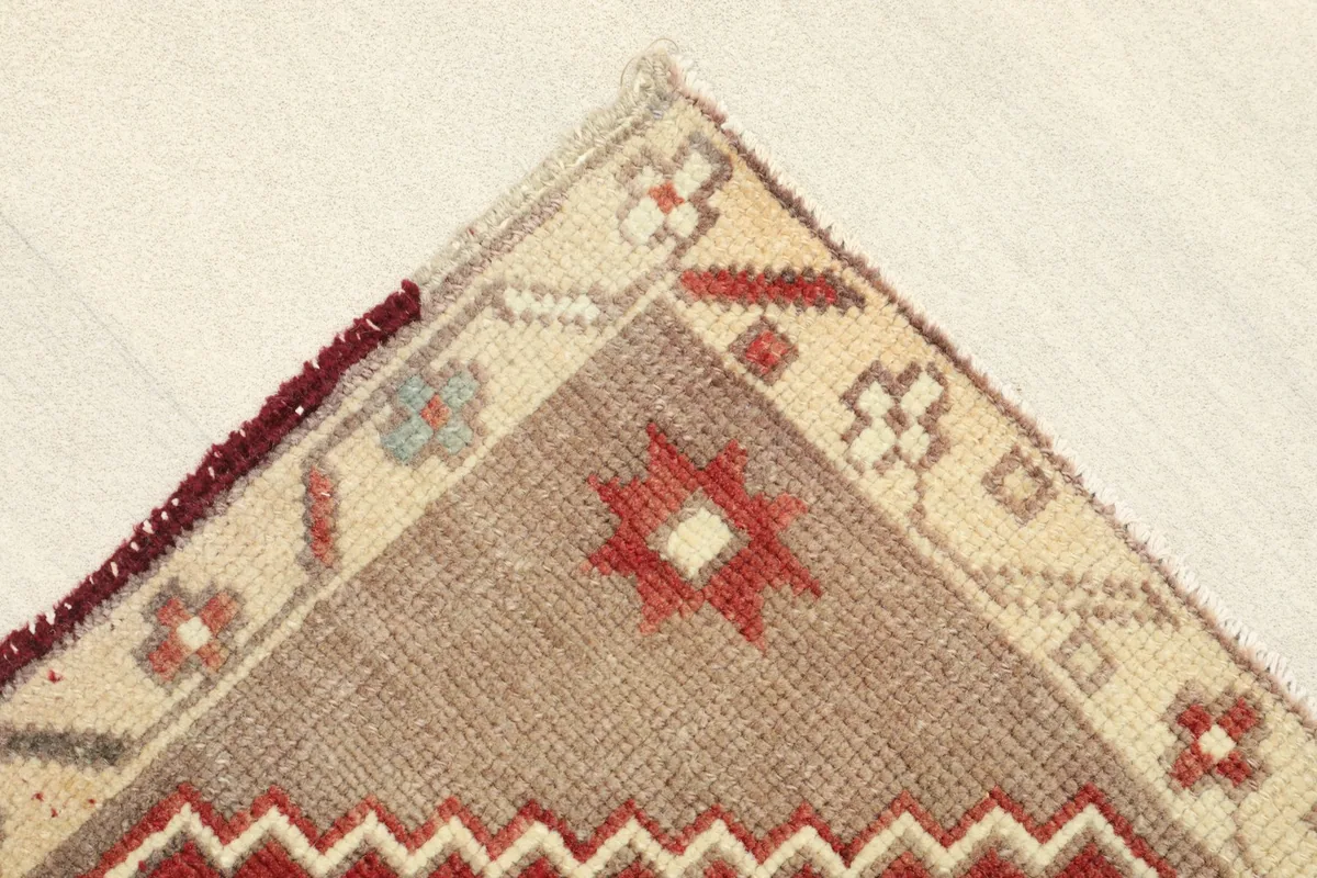 Corner detail showing the beige border with small red and gray motifs