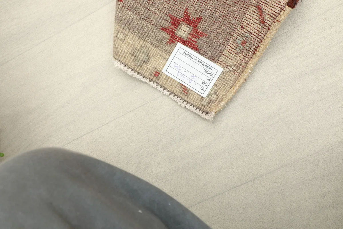 View of the rug's back, showing the hand-knotted construction and care label