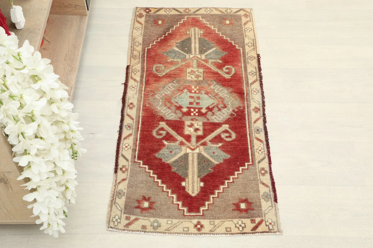 Direct overhead shot of the red vintage rug, showing its full design and colors