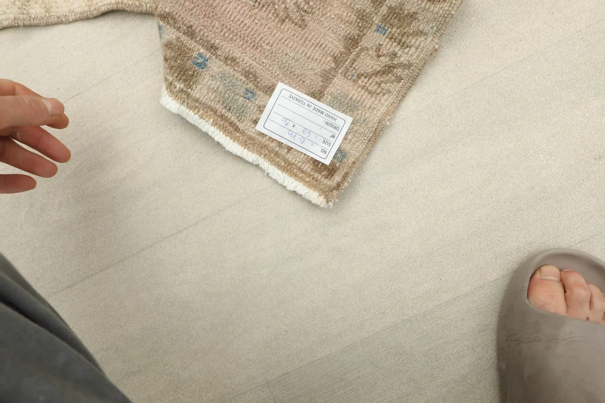 Close-up of the rug's back, confirming its hand-knotted technique and material tag.