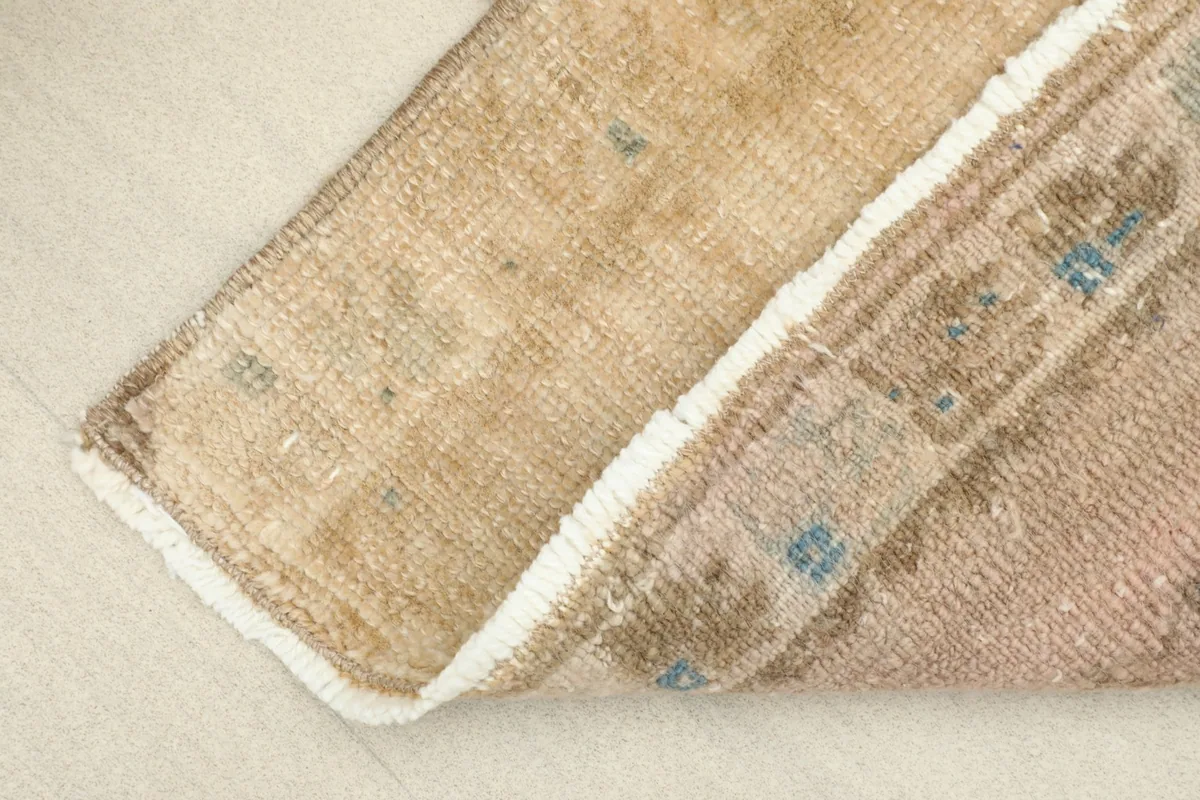 View of the rug folded to reveal the backside, showing the tight knotting.