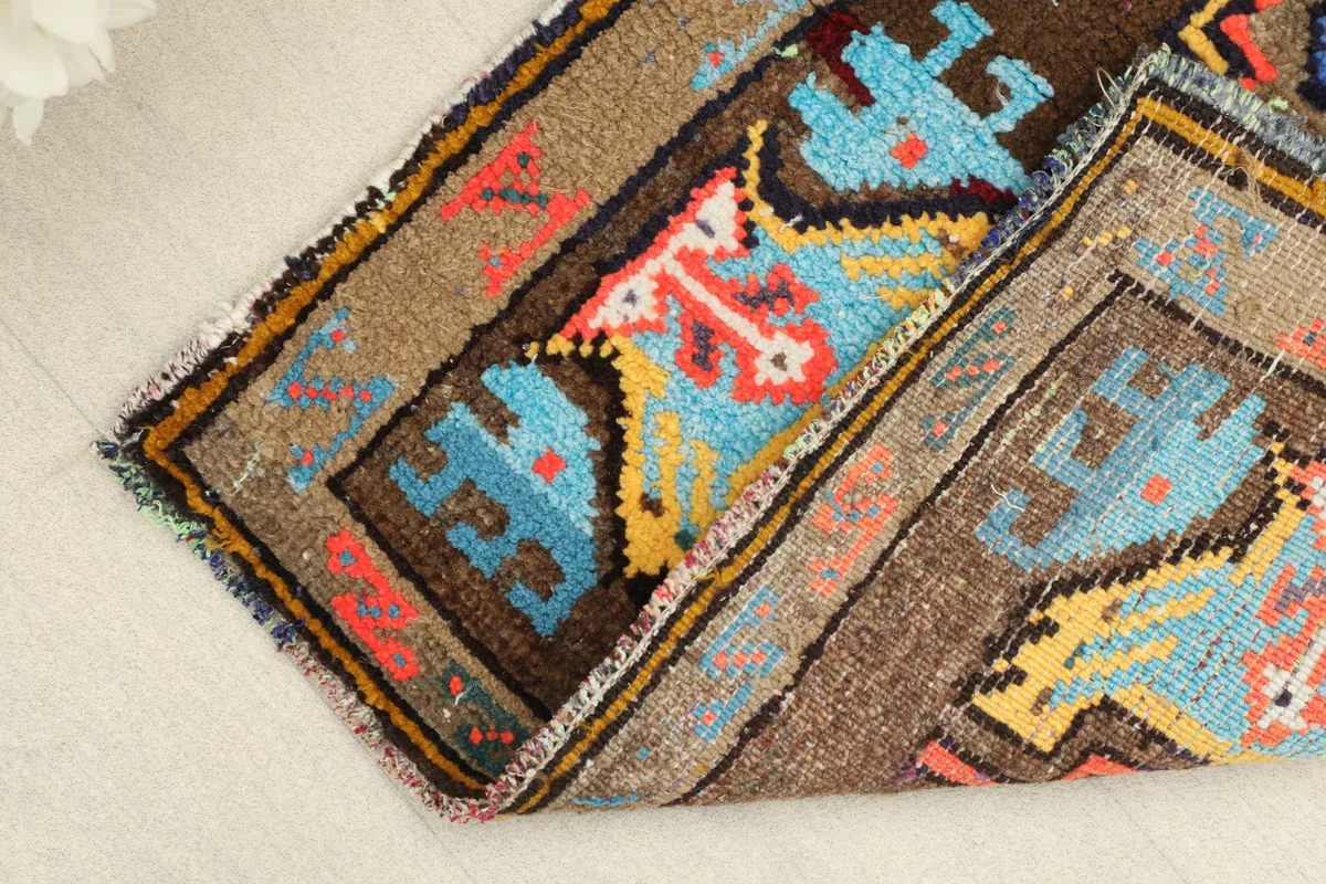 The small vintage rug folded to show its flexibility and thickness of the wool pile