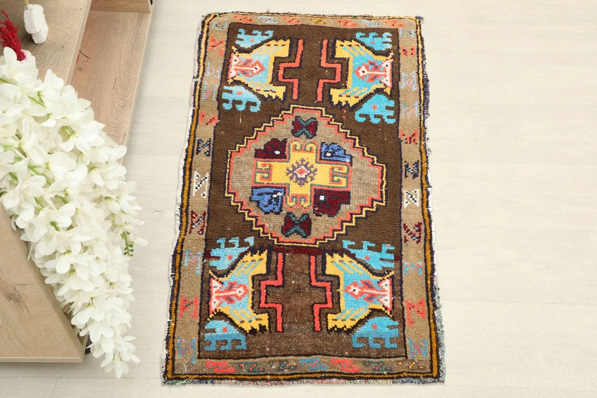Overhead view of the brown vintage rug, showcasing its geometric patterns and colors