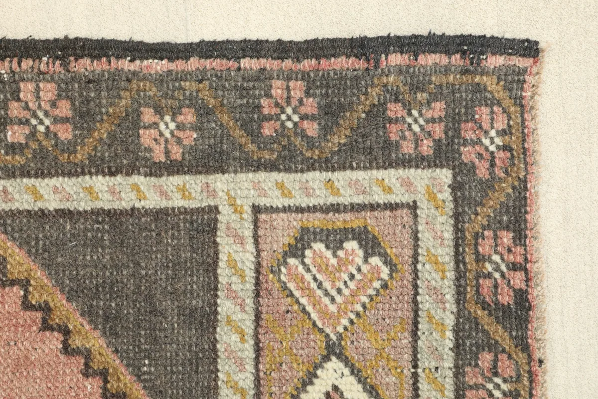 Edge detail of the rug, focusing on the border pattern and the transition to the main field.
