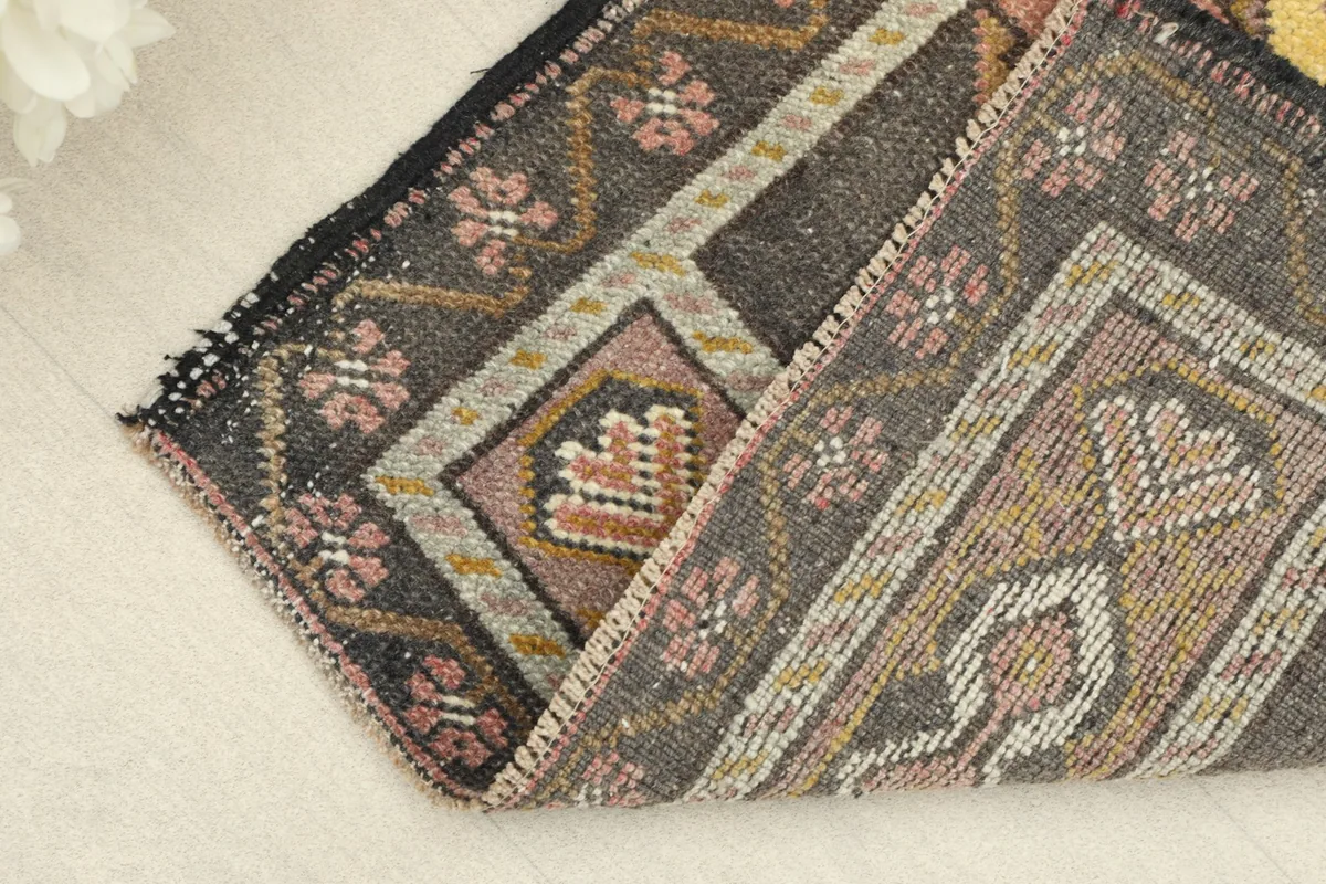 Folded section of the rug, revealing the low wool pile and the texture of the hand-knotted weave.