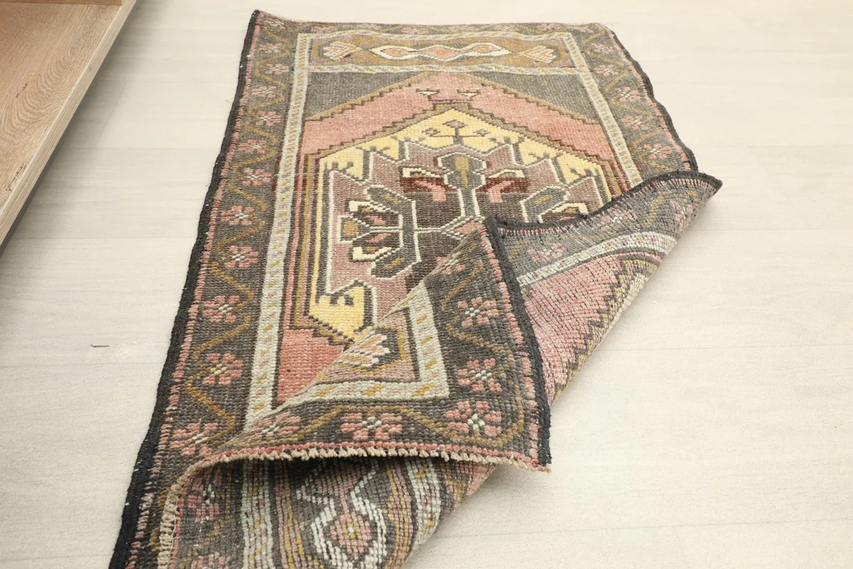 Rug partially folded, showcasing the flexibility and the reverse side of the hand-knotted construction.
