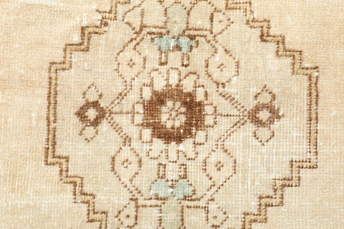 Detailed view of the intricate hand-knotted wool pile and subtle color variations within the central motif.