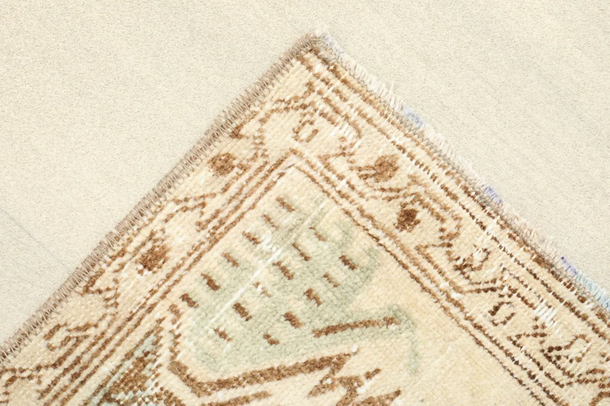Corner detail showing the geometric border design and the texture of the vintage wool pile.