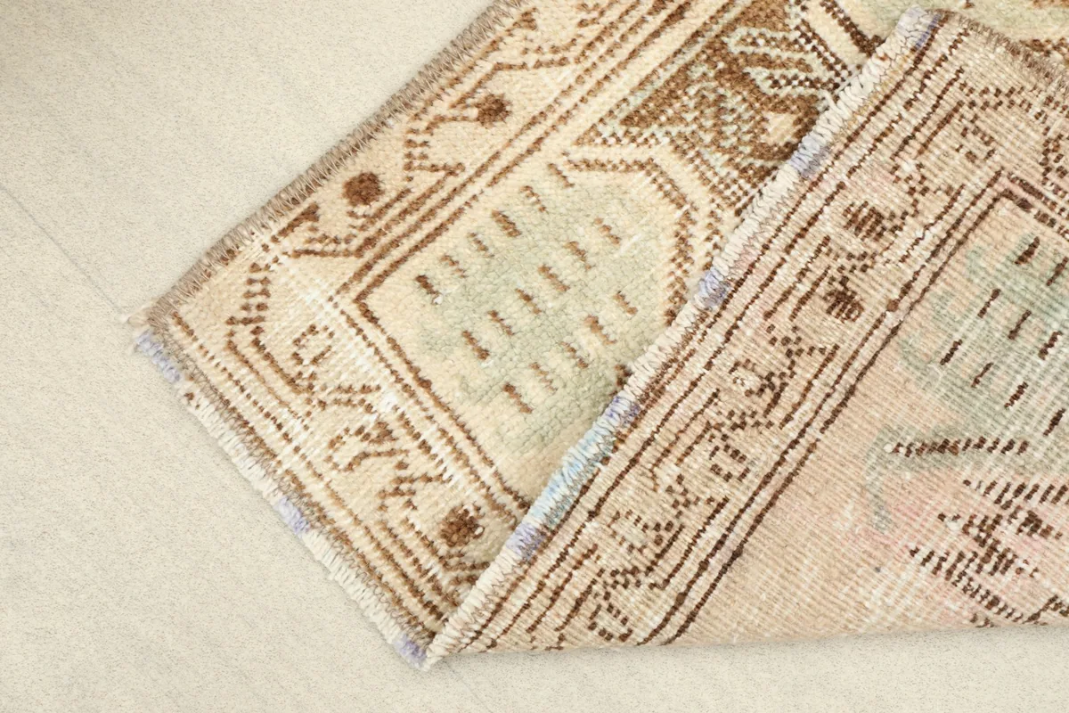 View of the rug folded, showing the flexibility and thickness of the hand-knotted wool construction.